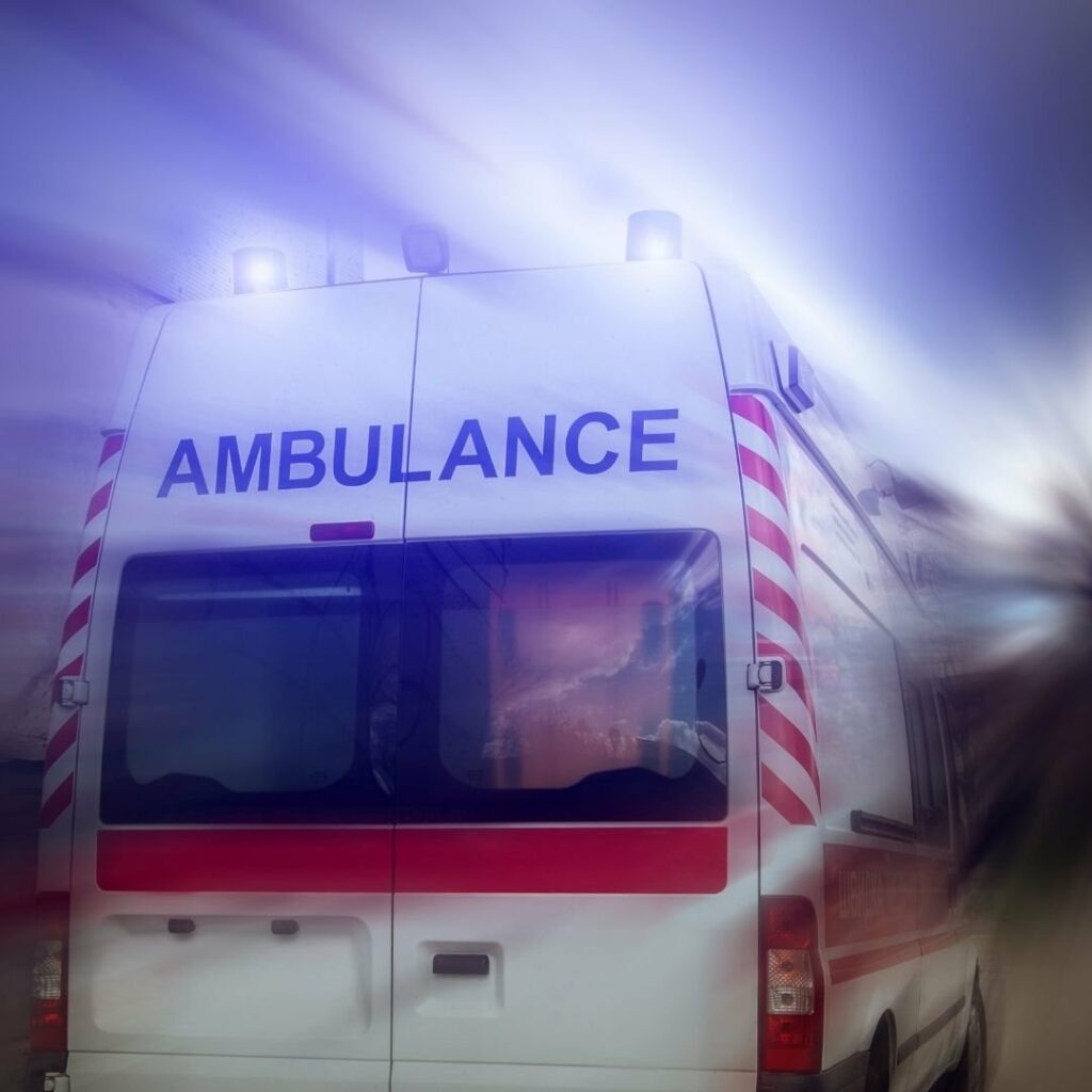 Ambulance blanche et écriture bleu de dos en train de rouler